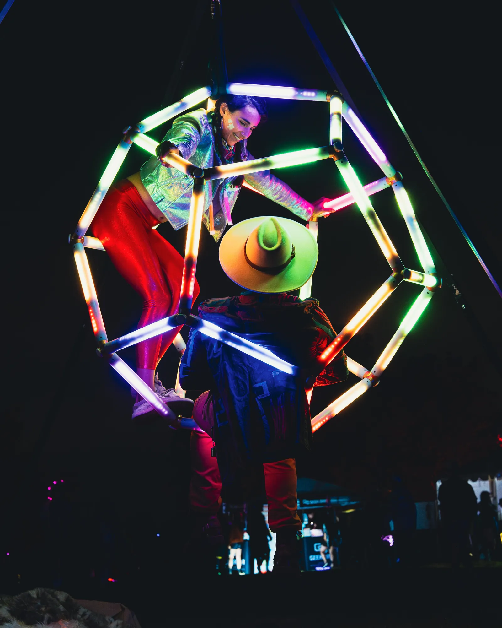 Performer inside a glowing LED dodecahedron at night