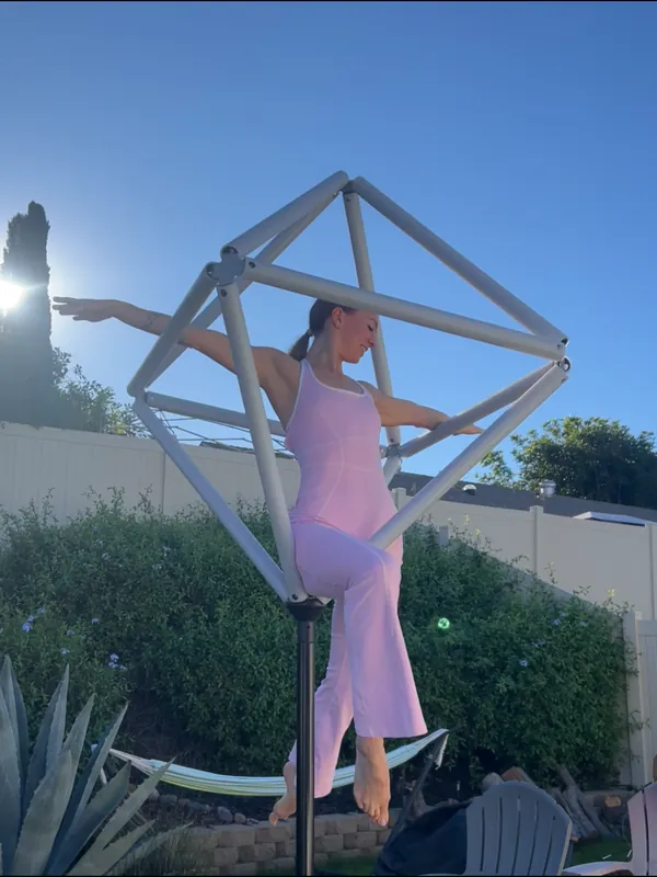 Performer on a diamond bipyramid geometric structure outdoors in daylight
